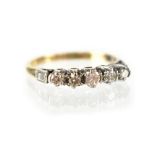 An 18ct gold ring set with five graduated diamonds in white gold claw setting, size L, stamped 18CT,