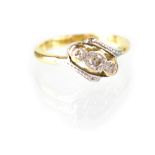 An 18ct gold ring set with three diamonds in cross band setting in white gold mount, stamped 18ct,