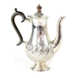 An Edwardian hallmarked silver coffee pot of baluster form with semi-gadrooned decoration,