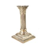 A Victorian hallmarked silver candlestick in the form of a Corinthian column on a square stepped