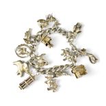A hallmarked silver charm bracelet with charms to include a teddy bear and various animals, etc.