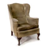 A George III style wing back armchair with outswept arms, upholstered in a mustard-coloured velvet,