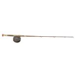 A late 19th century fishing rod of apparent one-piece construction with central brass screw reel