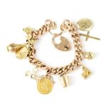 A 9ct gold charm bracelet with approximately eleven charms to include a 1904 half sovereign, church,