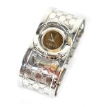 Gucci; a vintage ladies' white metal bangle-style wristwatch,