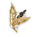 A yellow metal brooch in the form of leaves and a flower set with five sapphires and three diamond