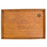 An early 20th century oak serving tray with carved border and inset King George VI Coronation