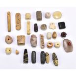 A group of ancient jewellery beads and trinkets of varied size and form including carved bone, stone