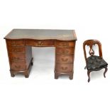 A reproduction mahogany veneered serpentine fronted kneehole desk, with green leather inset top