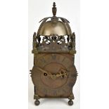 A 19th century brass lantern clock with turned finial above exposed bell and circular dial