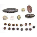 A group of ancient jewellery beads of varied size and form including carved stone examples, the