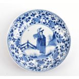 A Chinese 18th century porcelain saucer painted in underglaze blue, with two figures in garden