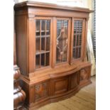 An early 20th century German oak Schranke with moulded cornice above glazed doors to a bow fronted