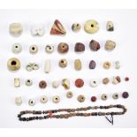 A group of ancient ceramic, glass and stone jewellery beads of varied size and form. Provenance: a