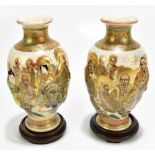 A pair of Japanese Satsuma vases with painted and relief decoration depicting immortals, each