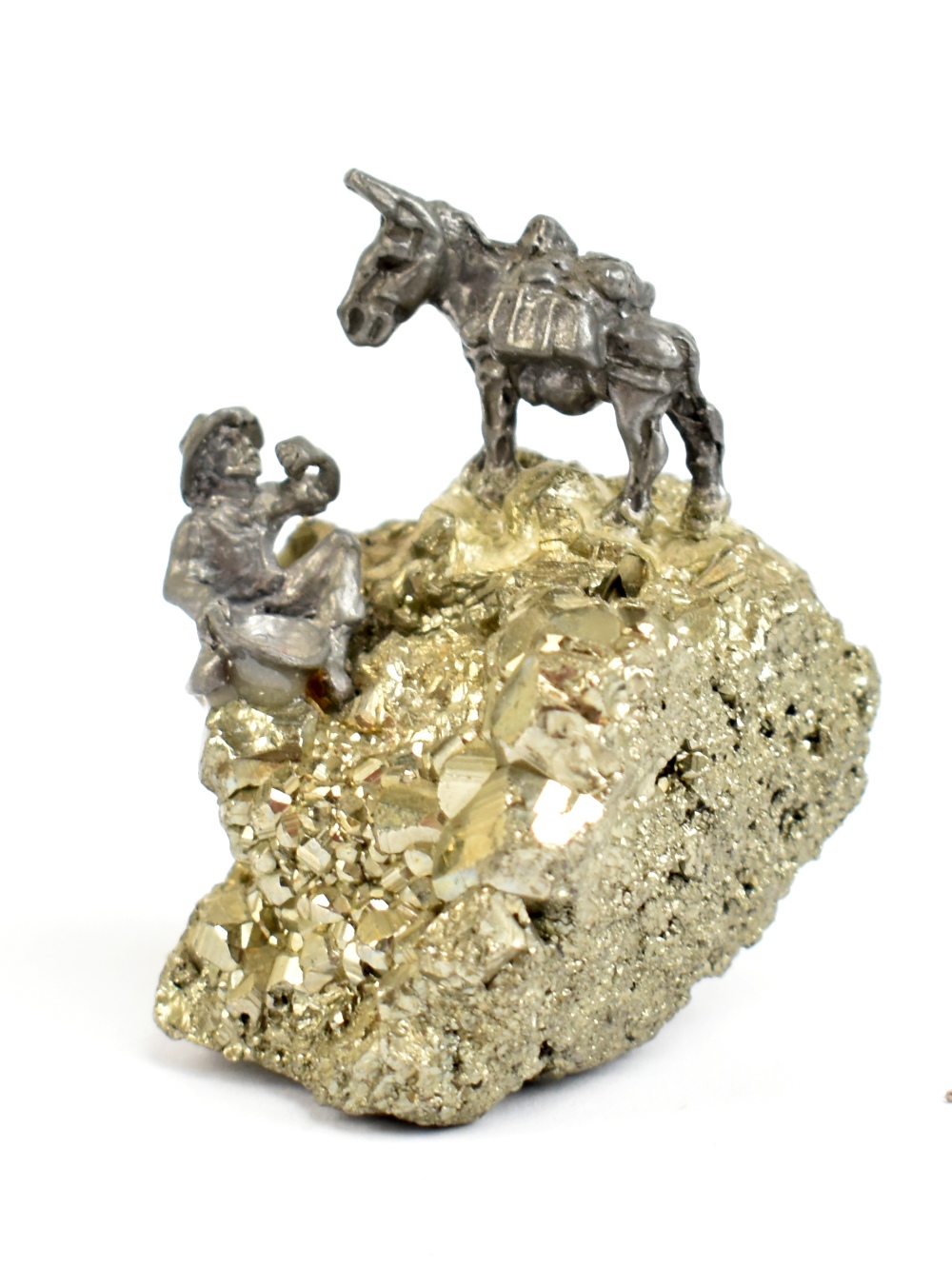 A small specimen of iron pyrite (fool's gold) surmounted with a small cast metal figure of a gold