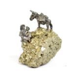 A small specimen of iron pyrite (fool's gold) surmounted with a small cast metal figure of a gold