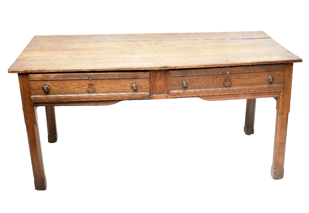 A late 19th century French oak two drawer writing table raised on chamfered square sectioned