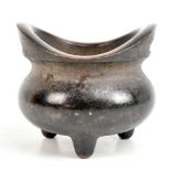 A Chinese bronze twin handled censer on three feet, four character seal mark to base, height 10.3cm,