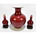 Three Chinese 20th century porcelain sang de boeuf glazed vases comprising bulbous example with