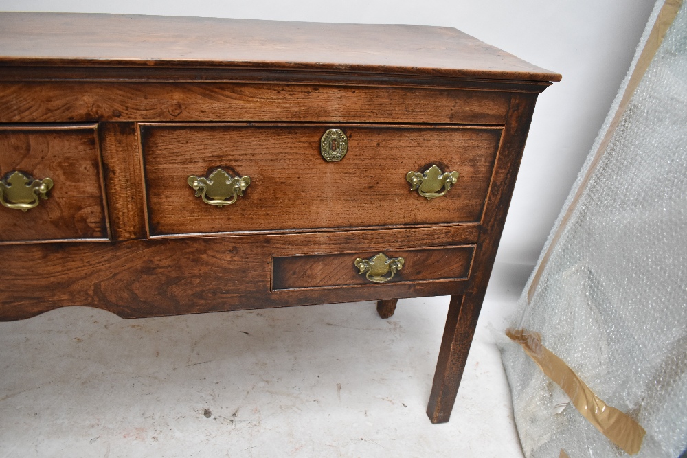 A George III oak and elm dresser base, the moulded rectangular top above three drawers with two - Image 5 of 6