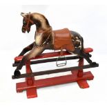 A 1950s wooden rocking horse, raised on red painted base, height 86cm. Additional InformationLarge