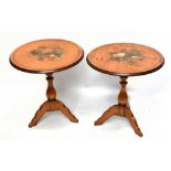 A pair of reproduction tilt-top occasional tables painted with fruit, raised on outswept supports,