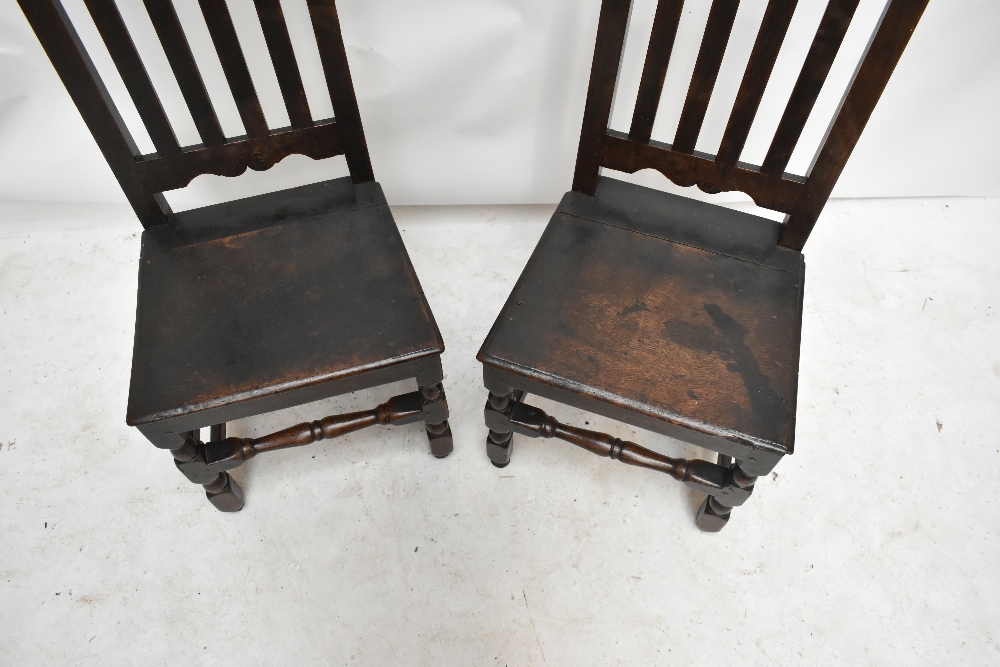 A pair of 18th century oak splat back hall chairs, raised on bun feet (2). - Image 2 of 2