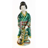 An early 20th century Japanese Kutani porcelain geisha, modelled standing with cat at her feet,