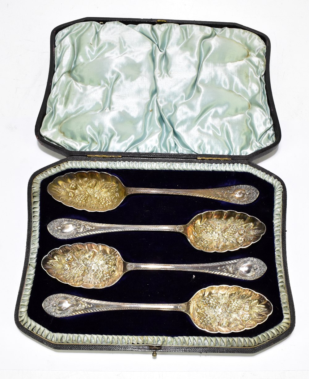 WALKER & HALL; a cased set of four Victorian hallmarked silver berry spoons, with cast decoration to