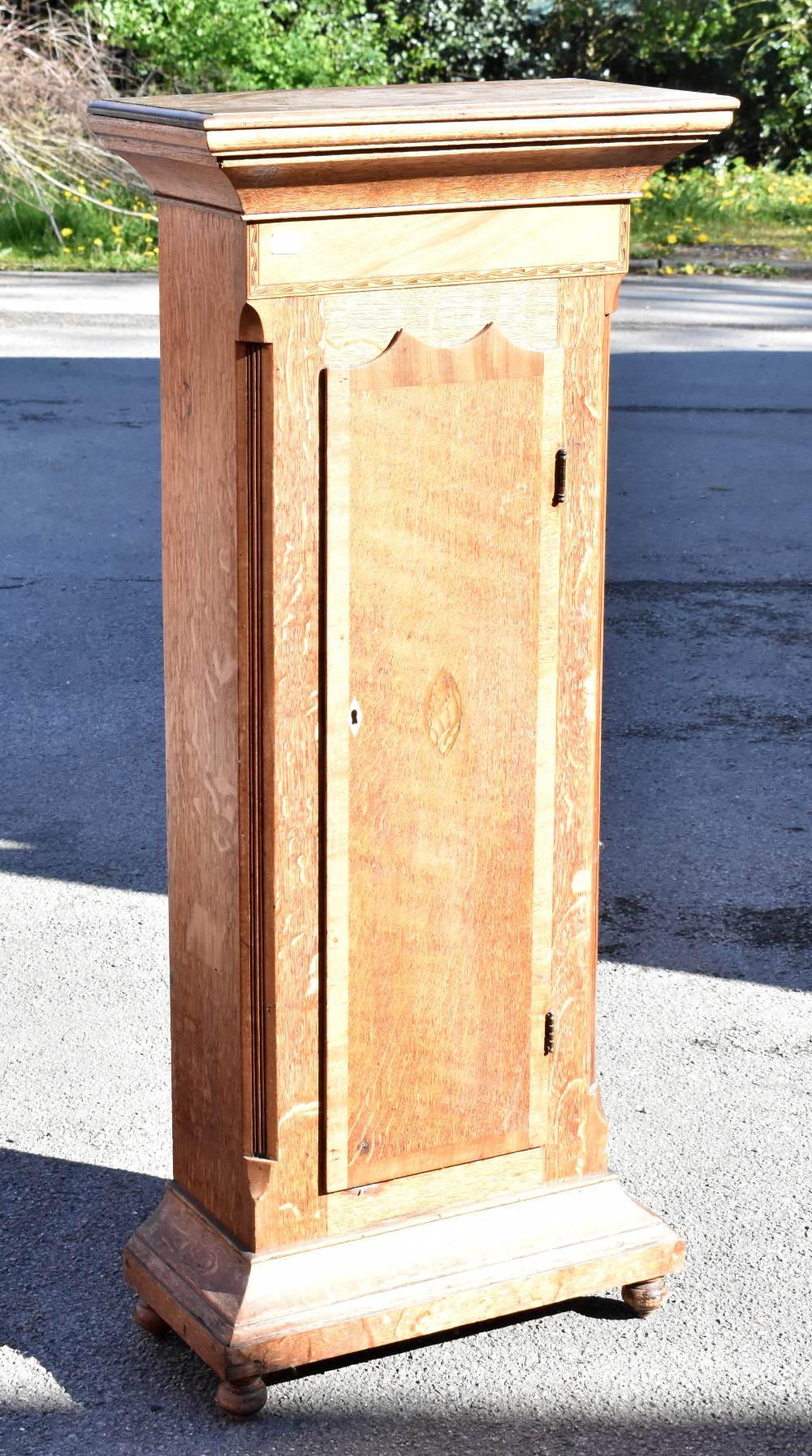 A 19th century inlaid oak cabinet in the form of a longcase clock body, the single door enclosing