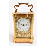 A  late 19th century French brass cased carriage clock, the central enamel dial with Arabic numerals