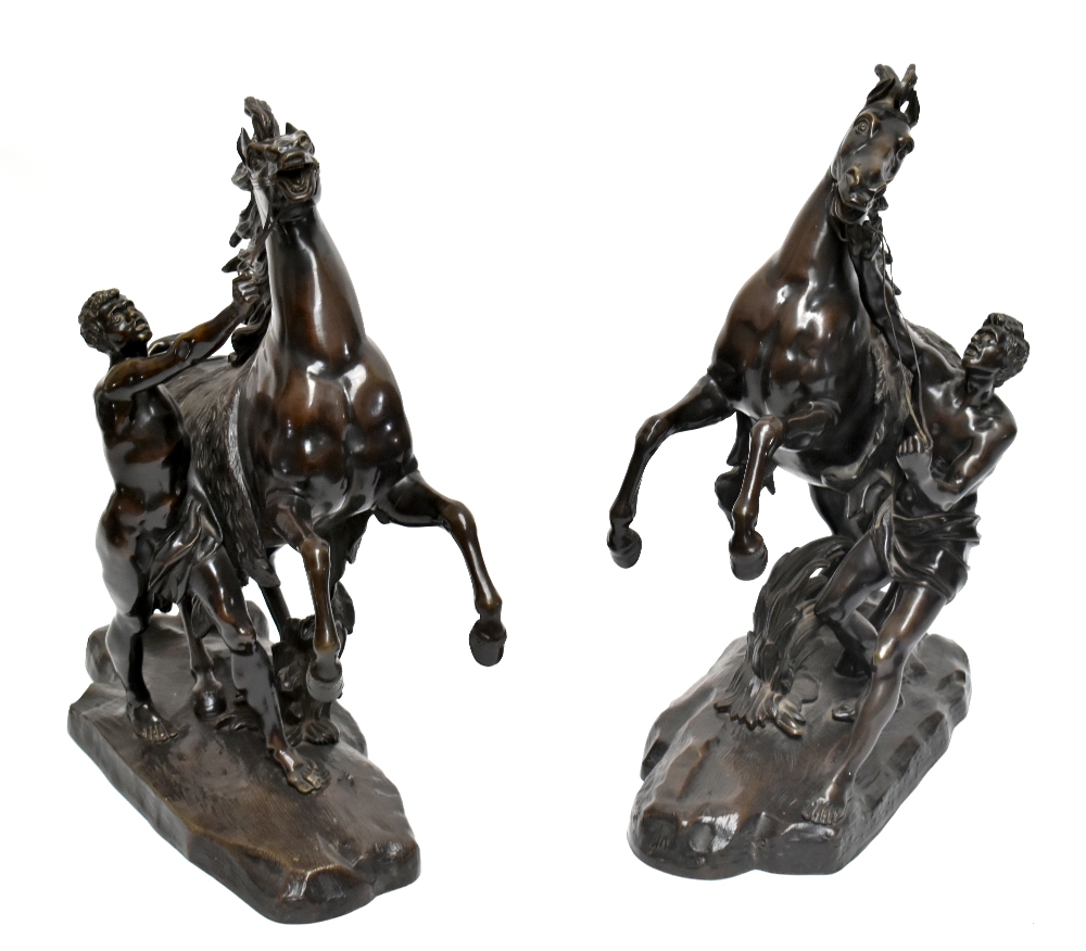 AFTER GUILLAUME COUSTOU; a very large pair of late 19th century bronze Marly horses, each bearing