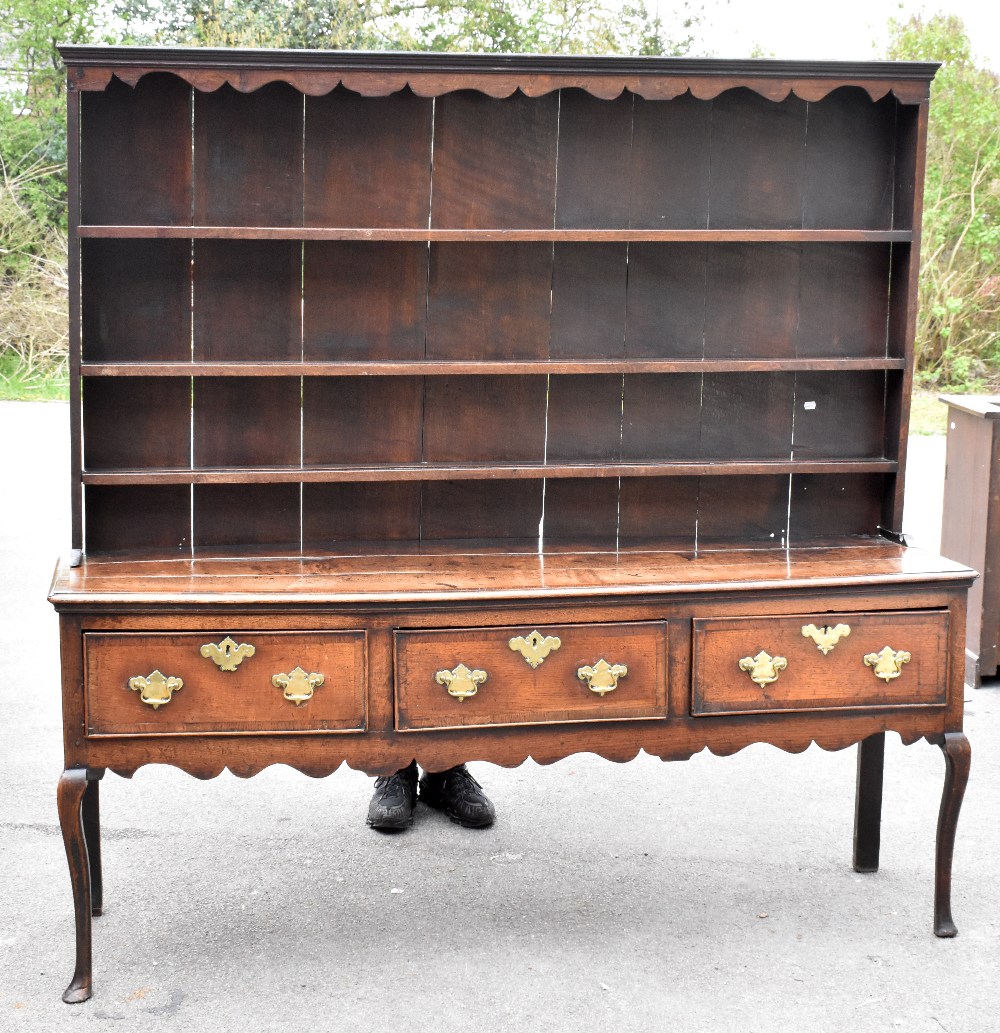 An 18th century oak dresser of low proportions, the plate rack back with carved and moulded