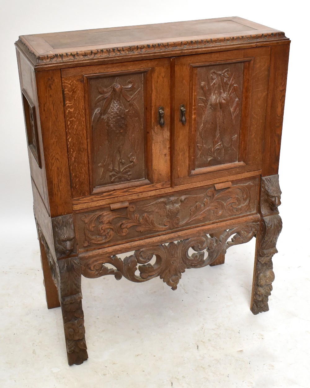 A late 19th century carved oak Black Forest-style side cabinet, the twin doors decorated with