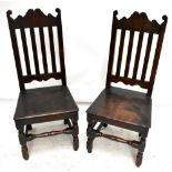 A pair of 18th century oak splat back hall chairs, raised on bun feet (2).