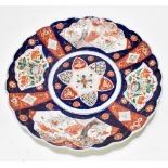 A 19th century Japanese Imari charged with scalloped edge, painted with panels depicting exotic