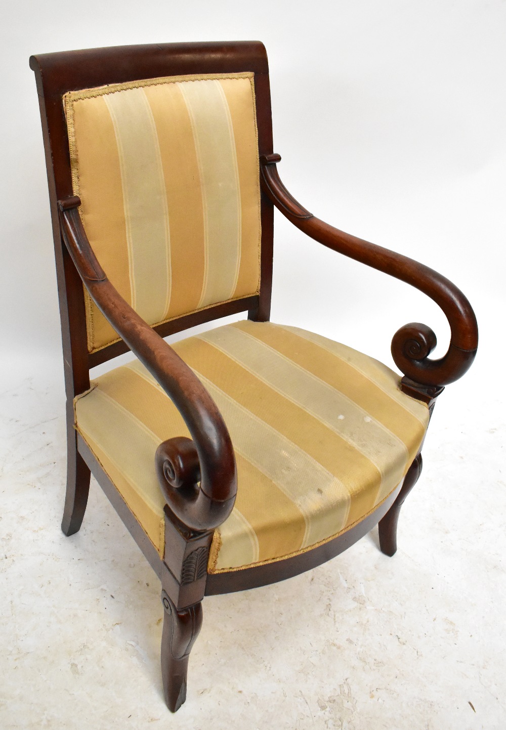 A 19th century French Empire mahogany elbow chair with padded back, scrolling swept arms, padded