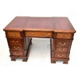 A reproduction pedestal desk with leatherette inset top, quarter turned columns and an arrangement