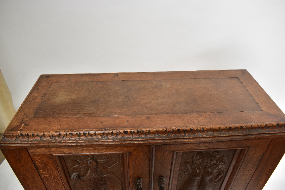 A late 19th century carved oak Black Forest-style side cabinet, the twin doors decorated with - Image 2 of 4