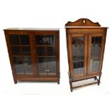 An early 20th century oak freestanding bookcase, the two leaded glazed doors enclosing an