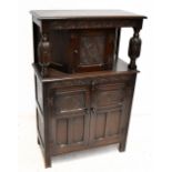 A reproduction oak court cupboard with single door to upper section, twin carved and panelled