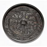 A Chinese steel hand mirror with cast decoration depicting a central tortoise in stylised detail,