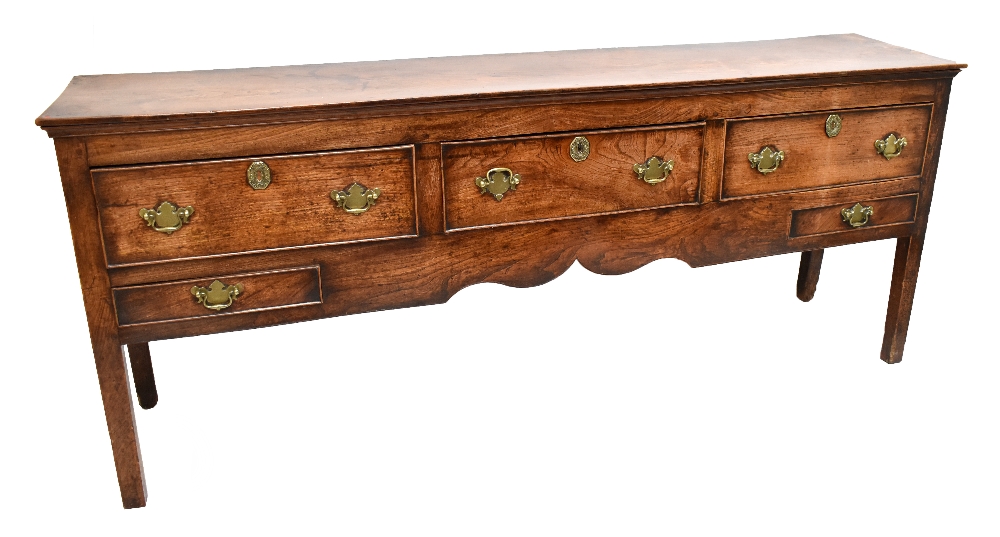 A George III oak and elm dresser base, the moulded rectangular top above three drawers with two