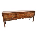 A George III oak and elm dresser base, the moulded rectangular top above three drawers with two