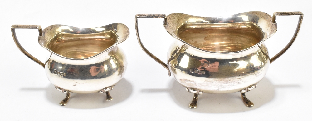 CHARLES EDWARD NIXON; an Edward VII hallmarked silver twin handled sugar bowl and cream jug, both on