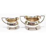 CHARLES EDWARD NIXON; an Edward VII hallmarked silver twin handled sugar bowl and cream jug, both on