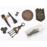 A group of medieval metal trinkets and tools including a shield shaped buckle with partially