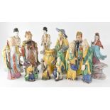 A collection of twelve Oriental figures to include ancient scholars, travelling men, female figures,