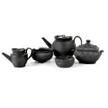 A group of four Wedgwood and other black basalt ceramics to include a teapot in the Oriental style